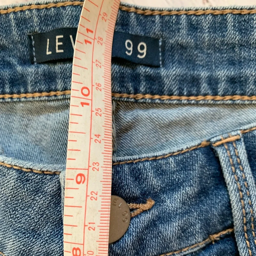 Level 99 jeans. Gold/silver design on bottom. Mid rise. Size 27.